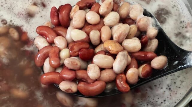 Stirring with a skimmer of kidney beans during its cooking