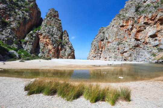 Sa Calobra. Balearic beach in a cove. Majorca beach. Mass tourism. Tourists on a protected beach.