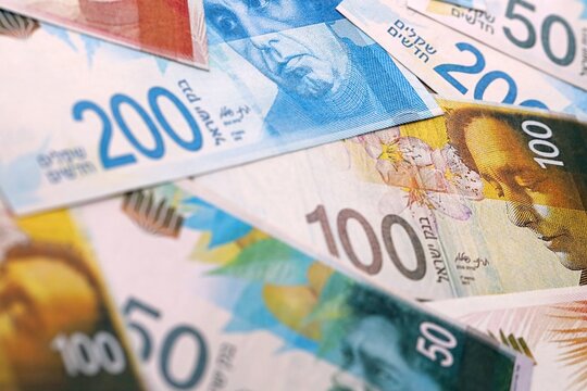 Israel shekel money bills pile on table. Israel banknotes of ILS currency close up.