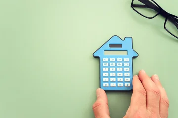 Calculator in the shape of a house. Idea of expenses and real estate © tomertu