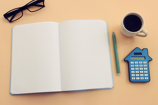 Top view image of empty notebook and calculator and cup of coffee