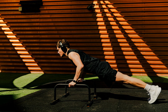 Athlete doing calisthenics pushup training outdoors in sunlight