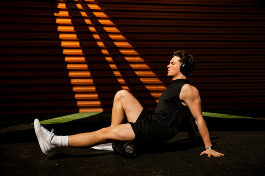 Athlete doing leg recovery with roller at the gym