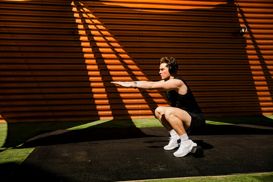 Athlete performing deep bodyweight squat outdoors