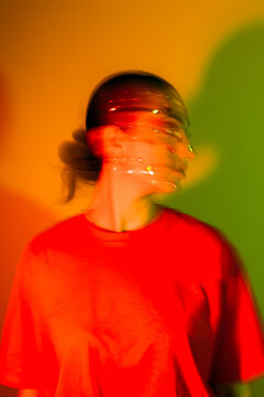 Young woman wearing red t-shirt against colorful background