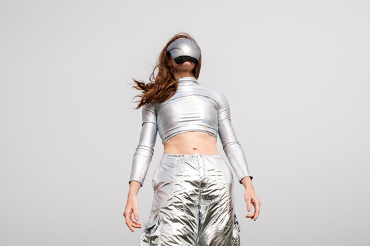 Futuristic cyborg in metallic clothes and VR visor outdoors