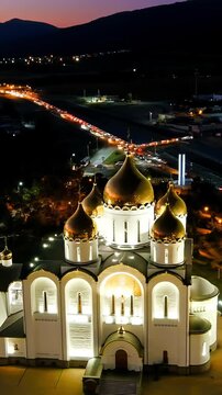 Vertical video. Gelendzhik, Russia. Cathedral of St. Andrew the First-Called. Andreevsky park. Night time. Drone footage, Departure of the camera. Rich colors