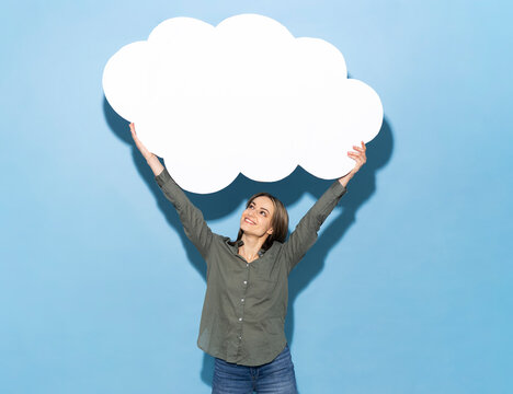 Woman holding a large blank white paper cloud against a blue background