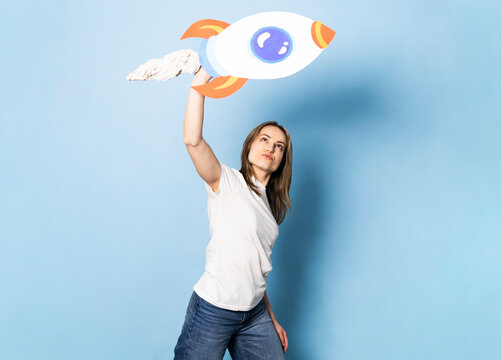 Woman holding a handmade paper rocket symbolizing success and ambition