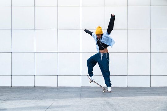 Skateboarder performing a jump trick against a geometric wall