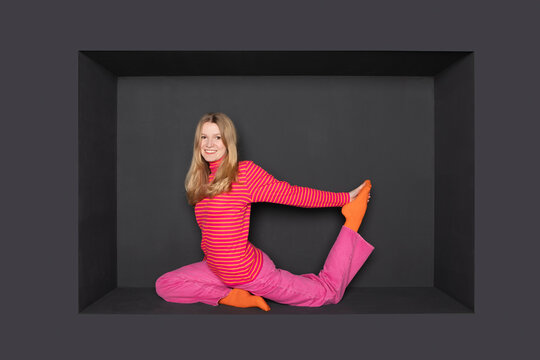 Smiling teenager stretching leg in alcove over background