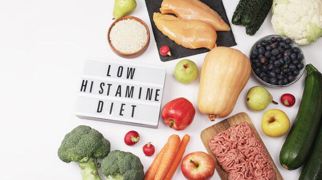 Flatlay of low-histamine diet foods around lightbox sign "Low Histamine Diet".