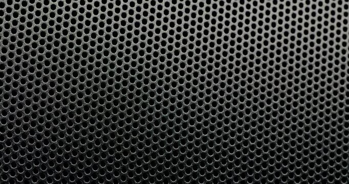 Black Perforated Metal Mesh. Smooth slow movement across extreme close-up of dark perforated metal grid. 