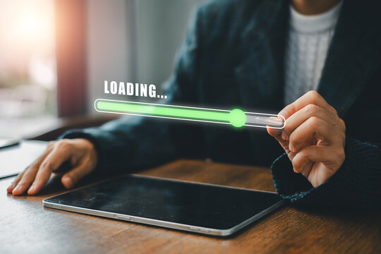Businessperson interacting with digital tablet displaying loading bar, symbolizing technology and progress.