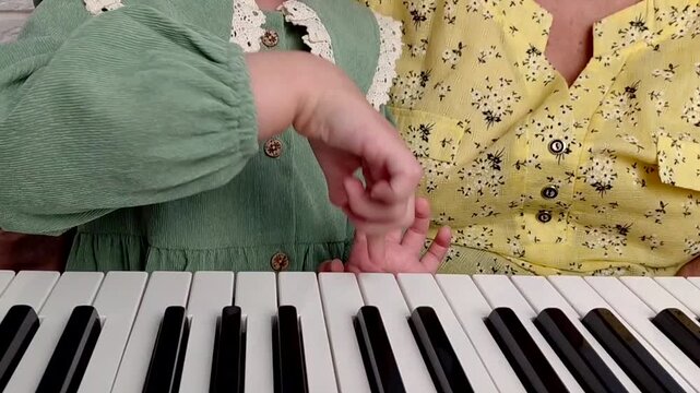 Elderly grandmother teaching little sweet girl playing piano, smiling with happiness, staying at cozy home, spending time together. Family, Love, Education Concept.