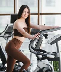 Fototapeta premium Young woman enjoying fitness workout at gym