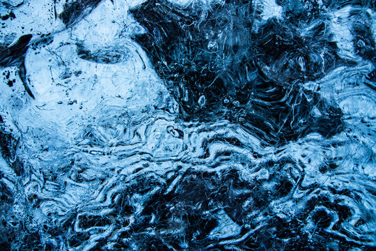View of an iceberg's frozen labyrinth of swirling blues and blacks, a textural masterpiece of nature's artistry, Glacier Lagoon, Sveitarfelagid Hornafjordur, Iceland.