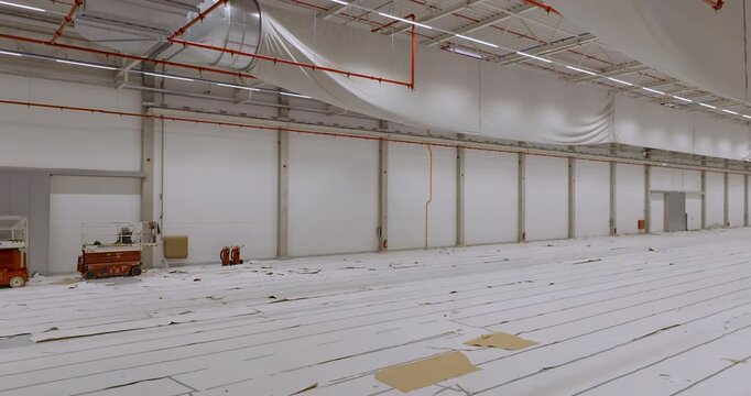 Empty commercial warehouse space with high ceilings and rows of loading bays