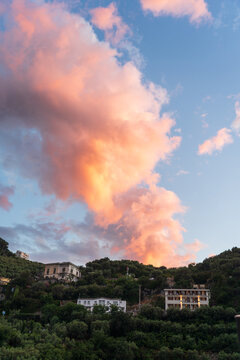 View of pastel skies meet the verdant slopes dotted with villas, a tranquil harmony of nature and architecture, bathed in the soft glow, Sorrento, Campania, Italy.
