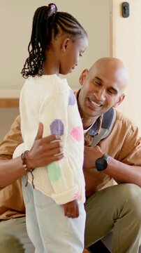 Father kneeling at door while briefing daughter, animated school list, route emerging from backpack