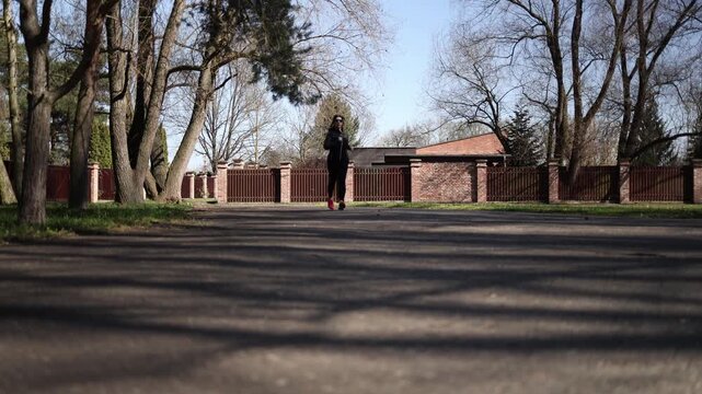 Woman starts her morning with light run in park building healthy habits boosting energy and mindset through fresh air movement and calm natural surroundings