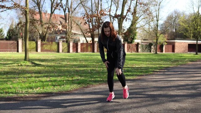 Woman during outdoor run feels recurring knee pain from previous injury stopping workout highlighting importance of recovery proper care and avoiding overtraining in fitness