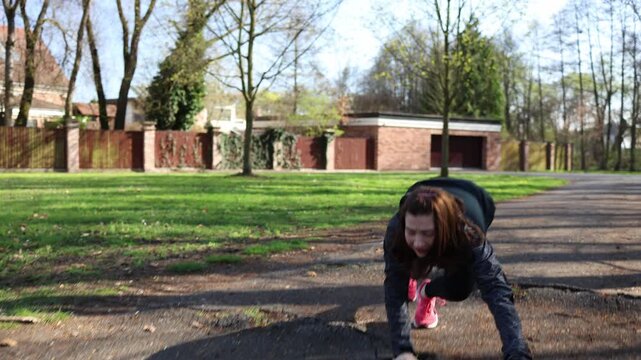 Woman running outdoors twists ankle and falls during workout showing risk of sudden injury importance of careful movement proper technique and safety in active lifestyle