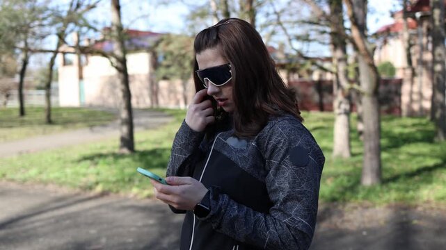 Woman interrupts outdoor workout to check smartphone handling tasks and messages showing distraction during training impact of digital habits on fitness focus and routine