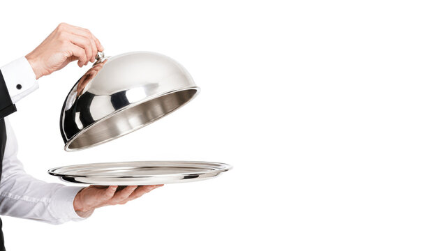 A waiter lifts a silver cloche, revealing an empty serving tray on a white background.