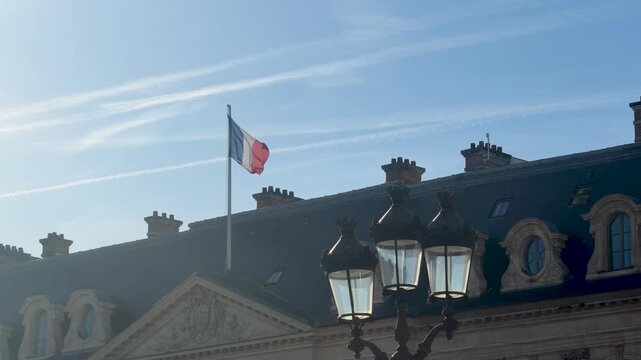 Historic Paris rooftops under blue sky with flags waving gently