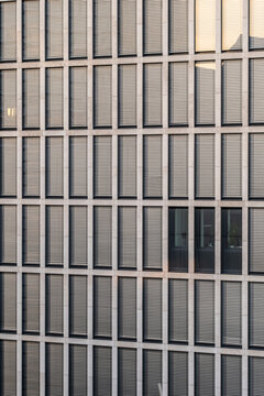 Modern architecture facade of office corporate finance shows pattern and symmetry as glass windows repeat in a strict grid for business backdrop