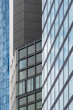 Modern architecture facade with glass windows shows office corporate finance pattern and symmetry in dramatic perspective of urban highrise details