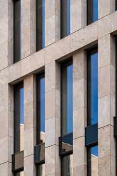 Modern architecture facade with office corporate finance pattern and symmetry framed by stone verticals and glass windows in formal urban exterior