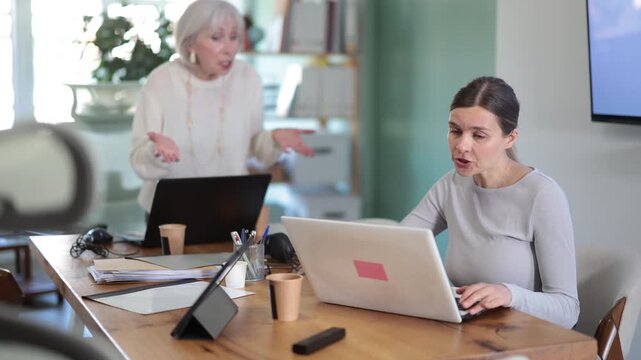 Senior female manager is dissatisfied with the work of an employee - she yells and reproaches her. High quality 4k footage