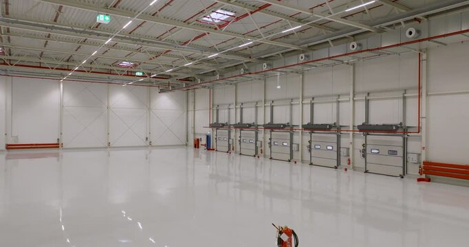 Wide angle view of empty industrial warehouse space with numerous loading bays