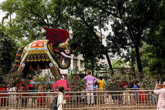 Dhaka, Bangladesh - 13 April 2026: View of a majestic, vibrantly decorated elephant float captivating onlookers amidst the lush green canopy.