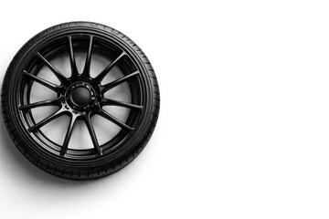 Obraz premium Flat lay of a sporty black alloy rim featuring summer tire on white background including copy space