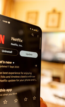 Person holding a smartphone to update the Netflix app in September 2023