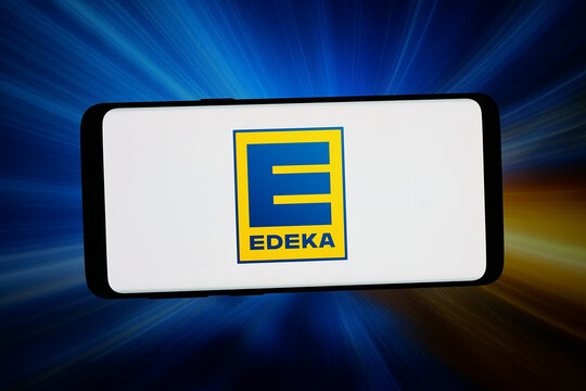 Stuttgart, Germany - 04-16-2026: In this photo illustration, the logo of German supermarket company Edeka Group is displayed on a smartphone in front of abstract background on computer screen.