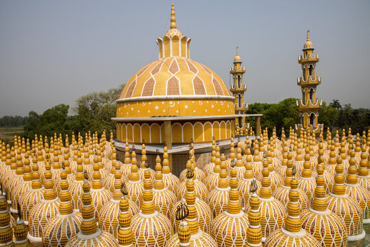 View of golden domes adorned with intricate white patterns rise majestically against the clear sky, creating a surreal and captivating scene, Tangail, Bangladesh.