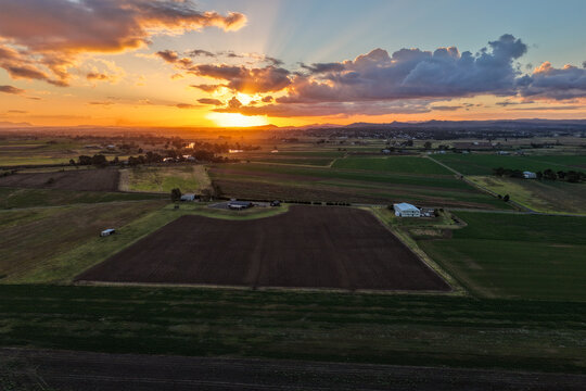Aerial view of sunset over farmland at Morpeth in New South Wales, Australia. Scenic rural landscape showing warm evening light across agricultural fields and countryside.