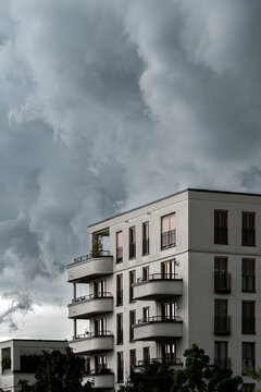 Urban residential apartments architecture facade in Frankfurt near Europagarten Germany with dramatic storm clouds framing a modern corner building exterior