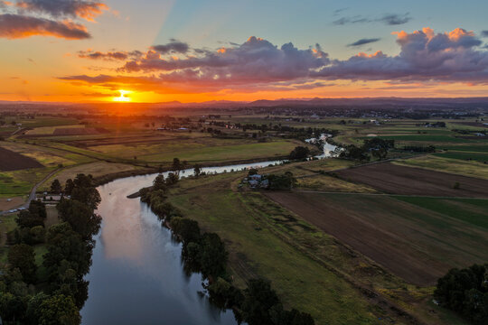 Aerial view of colourful sunset over Morpeth River and surrounding farmland in New South Wales, Australia. 