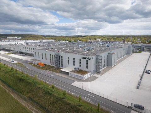 Large modern industrial building with multiple sections under a cloudy sky