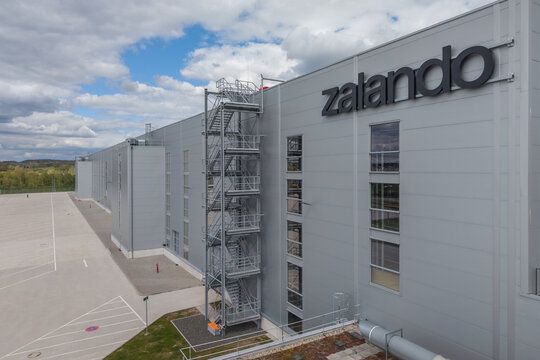Modern warehouse building exterior with Zalando lettering under the cloudy sky