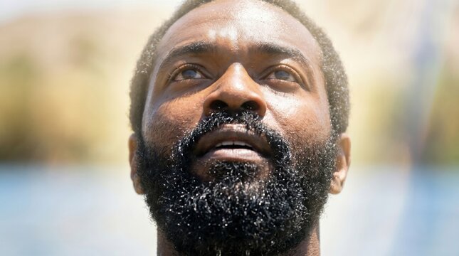 African man looking up at the sky with hopeful expression. Biblical representation of Ethiopian eunuch during divine encounter. Religious scene portraying faith and spiritual inspiration.