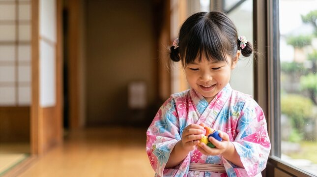 Close up of Japanese girl in yukata holding otedama beanbags with copy space