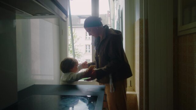 mother with cancer helping toddler step down from kitchen counter at home during chemotherapy showing parenting care safety and emotional resilience in daily life during illness