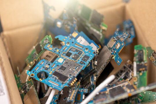 Multiple smartphone circuit boards arranged on table in electronics repair workshop