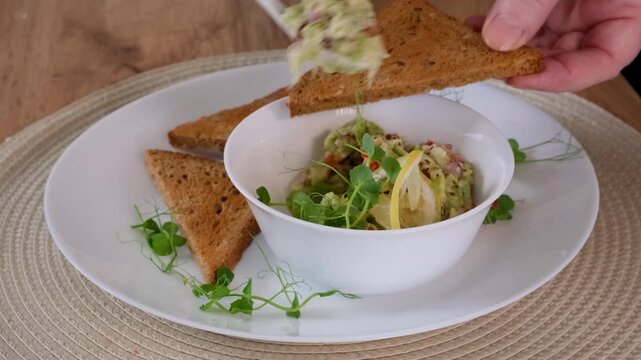 Spreading Guacamole on Toast Close Up Healthy Snack Preparation